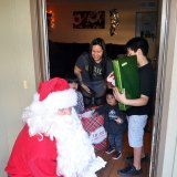 Santa greets another family as Lemoore police and friends visit homes as part of 'Presents on Patrol" held Friday in Lemoore.